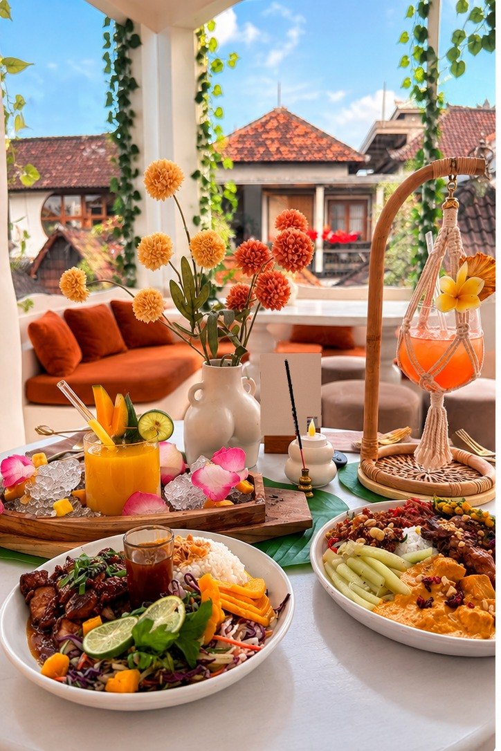 Tropical café table with curry, satay, mango drinks and flowers